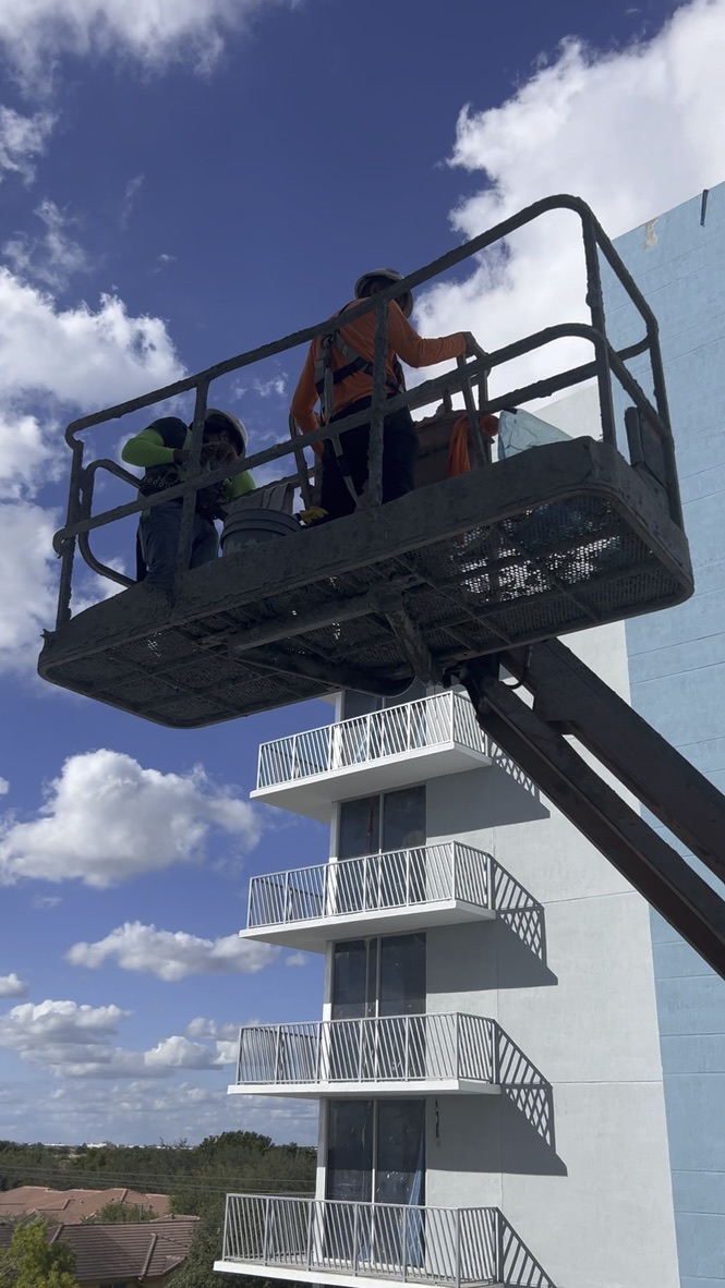 Window-cleaning team working from a lift on the upper storeys of the Doral building
